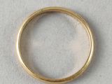 a close up of a gold ring on a white surface