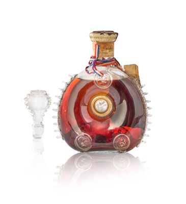 une bouteille d'alcool avec un bouchon en verre à côté