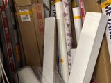 a pile of boxes and rolls of wrapping in a storage room