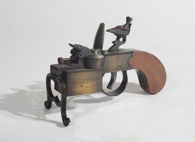 an old gun with a wooden handle on a white surface