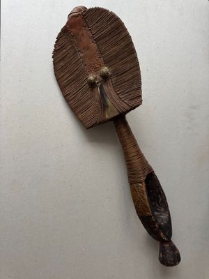 a wooden fan that is on the wall next to a mirror
