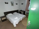 deux lits dans une chambre dont la porte est verte