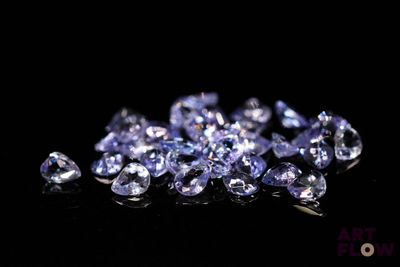 un gros plan sur un tas de saphirs bleus posés sur une surface noire