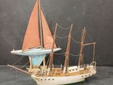 une petite maquette de voilier avec une voile rouge