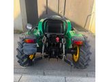 a picture of a green tractor parked on the side of the road