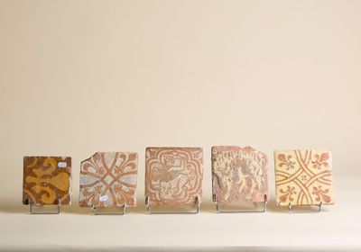 cinq petits carreaux posés sur une table, sur fond blanc
