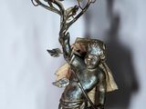 a statue of an angel holding a branch of a tree