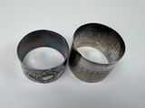 pair of silver bracelets on white surface with a white background