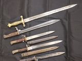 several different types of knives are lined up on a black cloth