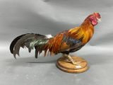 a statue of a rooster standing on a wooden base