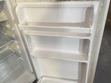 a white refrigerator with its door open in a garage
