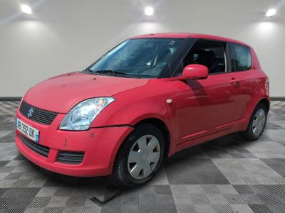 la petite voiture rouge est garée dans le garage sur un sol en damier
