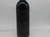 une vieille bouteille de vin posée sur une table blanche