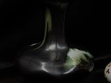 two vases sitting next to each other on a black surface
