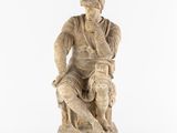 an old statue of a man sitting on a chair with a dog