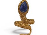 un gros plan d'une bague en or avec une pierre bleue au centre
