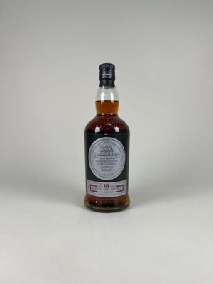 une bouteille de whisky posée sur une surface blanche