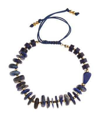 un collier composé de perles bleues et dorées sur fond blanc