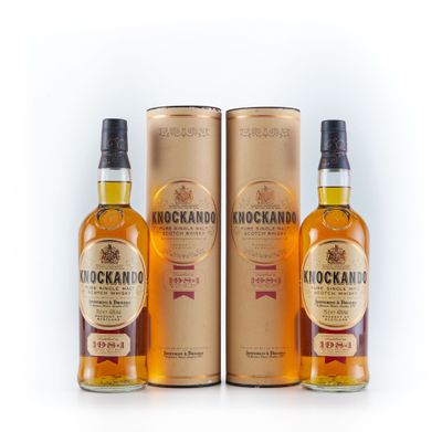 trois bouteilles de whisky sont posées les unes à côté des autres sur une surface blanche