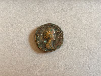 gros plan d'une pièce de monnaie sur laquelle figure un visage de femme