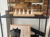 a black shelf with jewelry on it in a room