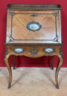un bureau ancien doté d'un plateau en bois et de sculptures ornées