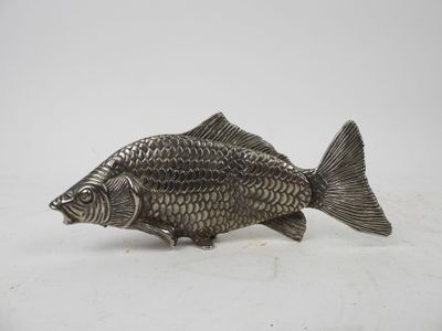 an antique silver fish figurine on a white background