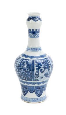 un vase bleu et blanc posé sur une surface blanche