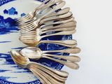 a blue and white plate with silver spoons and spoons on it