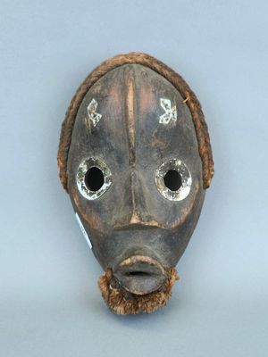 une image représentant un masque en bois percé de trous au niveau du visage