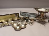 a silver plate and silverware on a white table