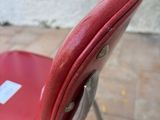 a red chair that has a tag on the back of it