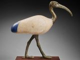 an image of a statue of a bird on a wooden base