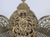 a large ornate gold clock sitting on top of a metal stand