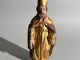 une image représentant une figurine d'un homme portant un chapeau et une robe