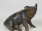une image représentant une statue de cochon assis sur ses pattes arrière