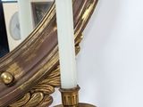 a candle that is sitting on a table in front of a mirror