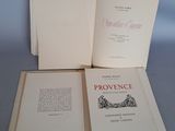 trois livres ouverts posés les uns sur les autres sur une table