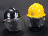 pair of yellow and black hard hats with face shields on a black background