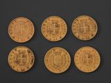 four different types of gold coins on a black surface