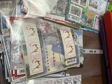 beaucoup de timbres posés sur une table, à côté d'un dossier rouge