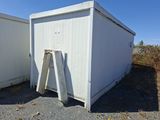 un petit bâtiment blanc avec une porte et une fenêtre