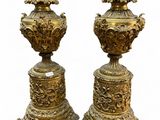 pair of antique brass urns on pedestals on a white background
