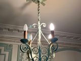 a chandelier with three lights hanging from it ' s ceiling