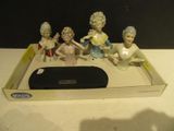 cinq figurines posées sur un plateau posé sur une table