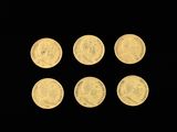 six gold coins are arranged in a row on a black background