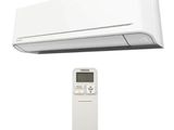 une photo d'un climatiseur blanc posé à côté d'une télécommande