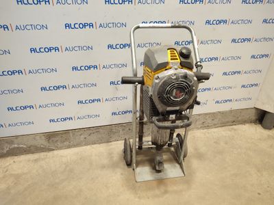 a silver and yellow machine sitting on top of a floor next to a wall
