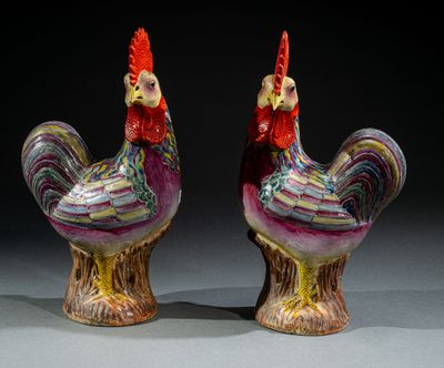 une paire de figurines de coqs en céramique colorées posées sur une table