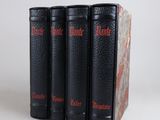 three black books sitting on top of each other on a white surface